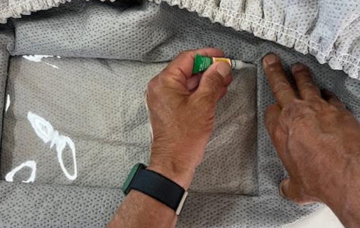 Applying super glue to secure fabric tabs in Viraport frame